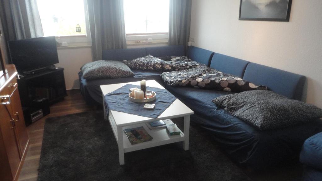 a living room with a blue couch and a table at Ferienwohnung Ol Komede Wai 12c in Helgoland