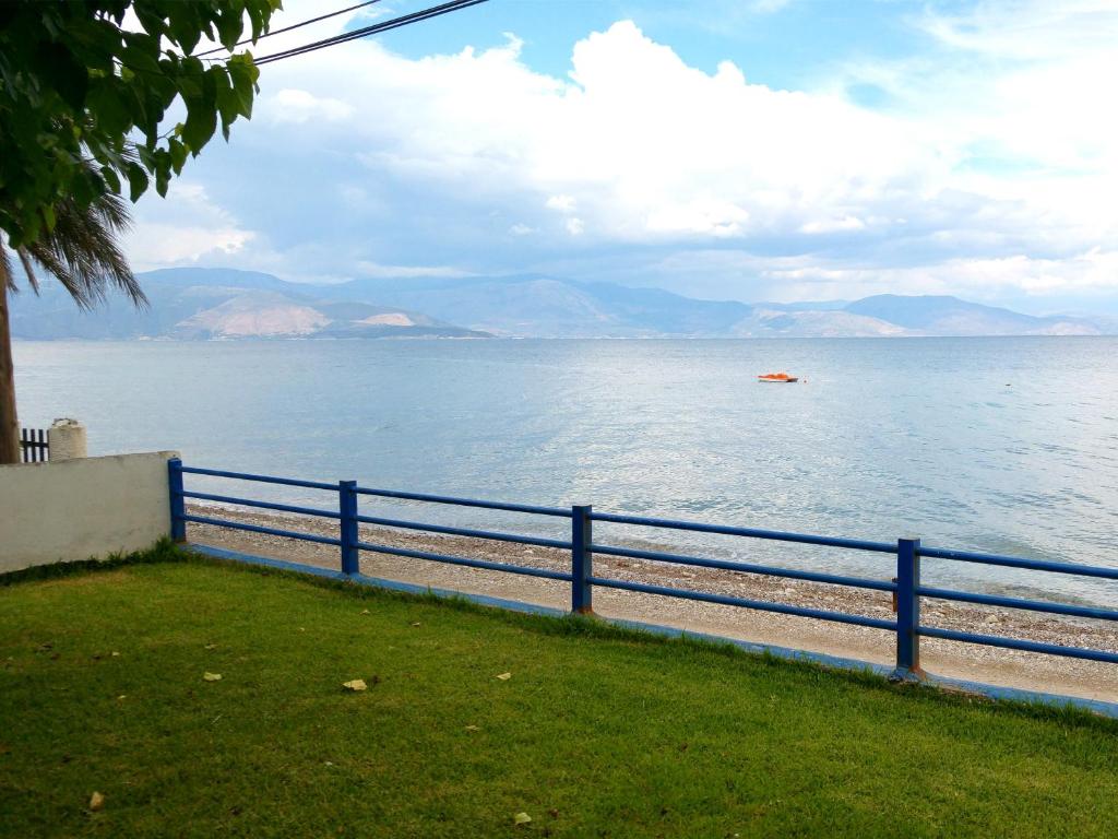 a blue fence next to a body of water at Papadogiannopoulos House in Aigio