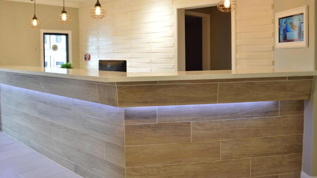 a reception counter in a lobby with wood at America's Best Value Inn - Memphis Airport in Memphis