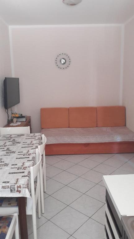 a room with a couch and tables and a tv at Apartment Smajlovic in Kukci