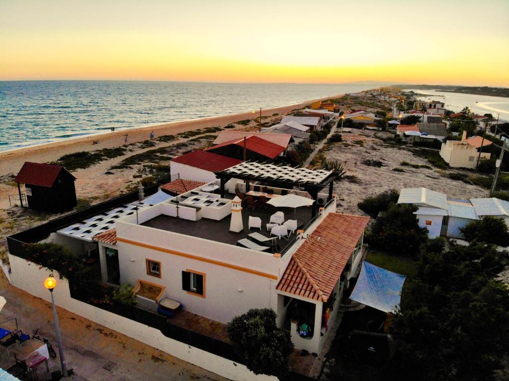 uma vista aérea de uma casa ao lado do oceano em Faro Beach House em Faro