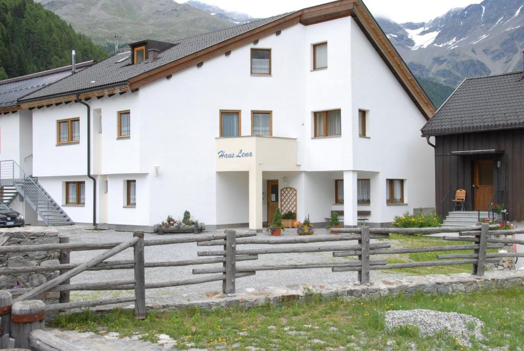 a large white building with a fence in front of it at Haus Lena in Solda