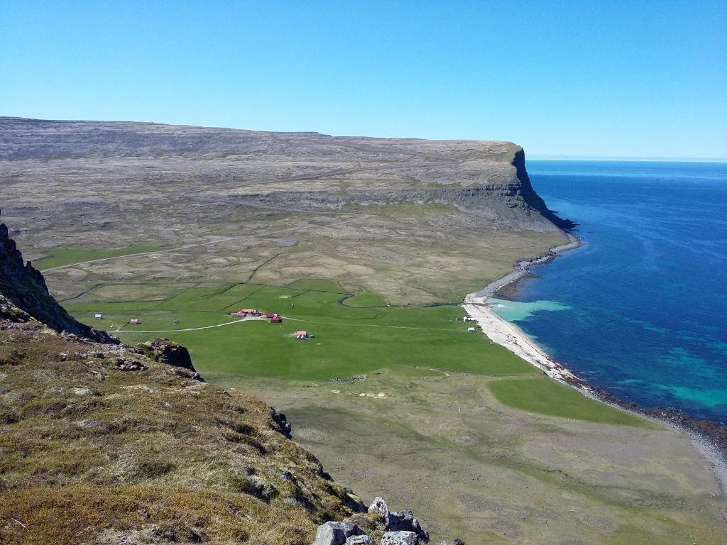 an aerial view of a golf course next to the ocean at Hænuvík Cottages in Hnjótur