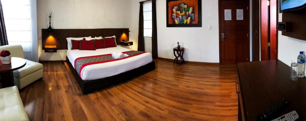 1 dormitorio con 1 cama y suelo de madera en Hotel Santiago de Compostella Suites, en Cuenca