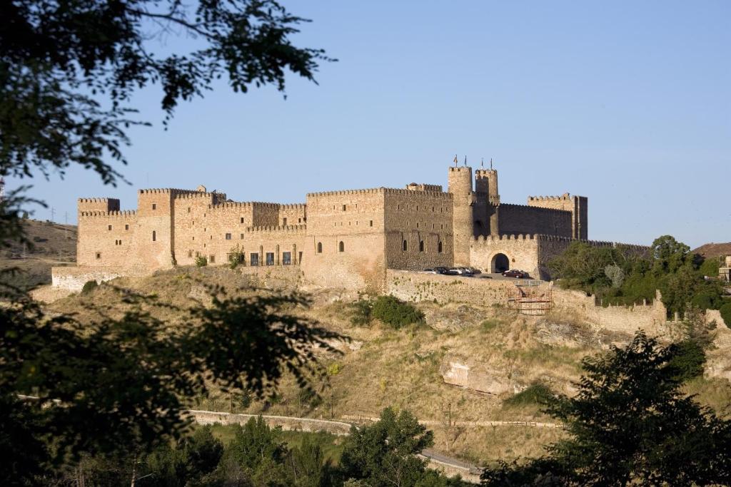 a large castle on top of a hill at Parador de Siguenza in Sigüenza