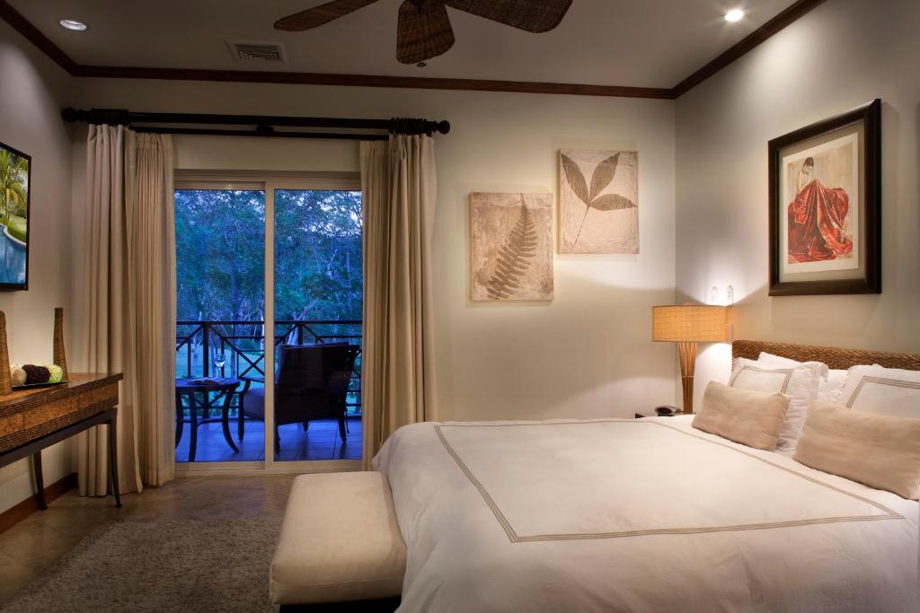 a bedroom with a bed and a balcony at Los Suenos Resort Veranda 6D in Herradura