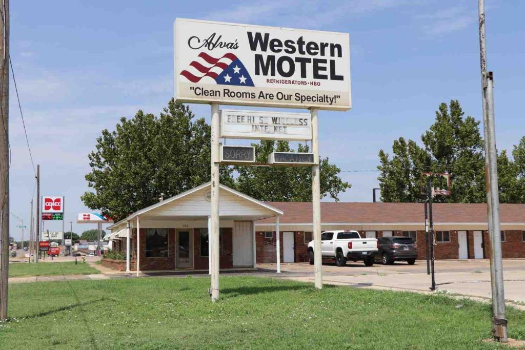 Western motel في Alva: علامة لموتيل غربي أمام متجر