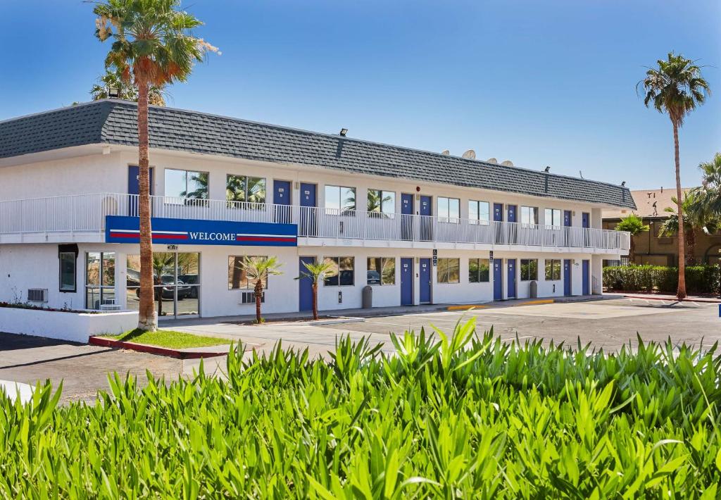 un bâtiment avec des palmiers en face de celui-ci dans l'établissement Motel 6-Blythe, CA, à Blythe