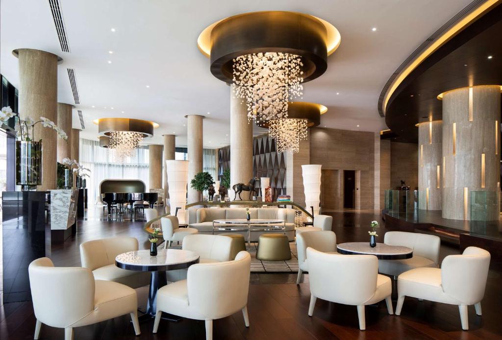 a lobby of a hotel with tables and chairs at Grand Hyatt Abu Dhabi Hotel & Residences Emirates Pearl in Abu Dhabi