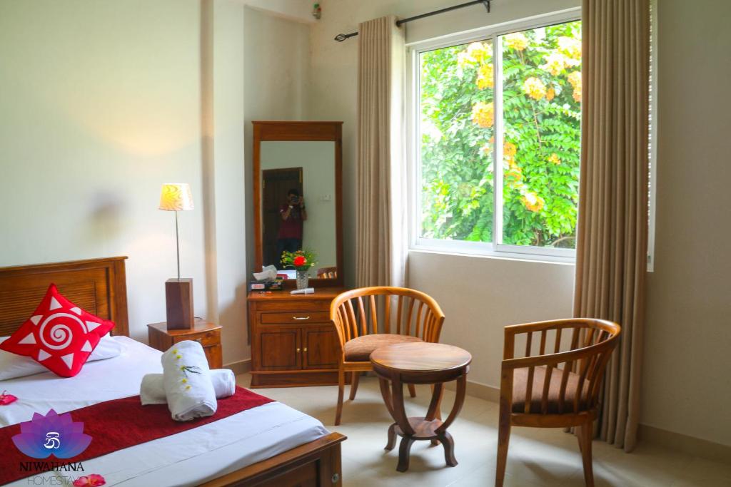 Postel nebo postele na pokoji v ubytování Nivahana Homestay