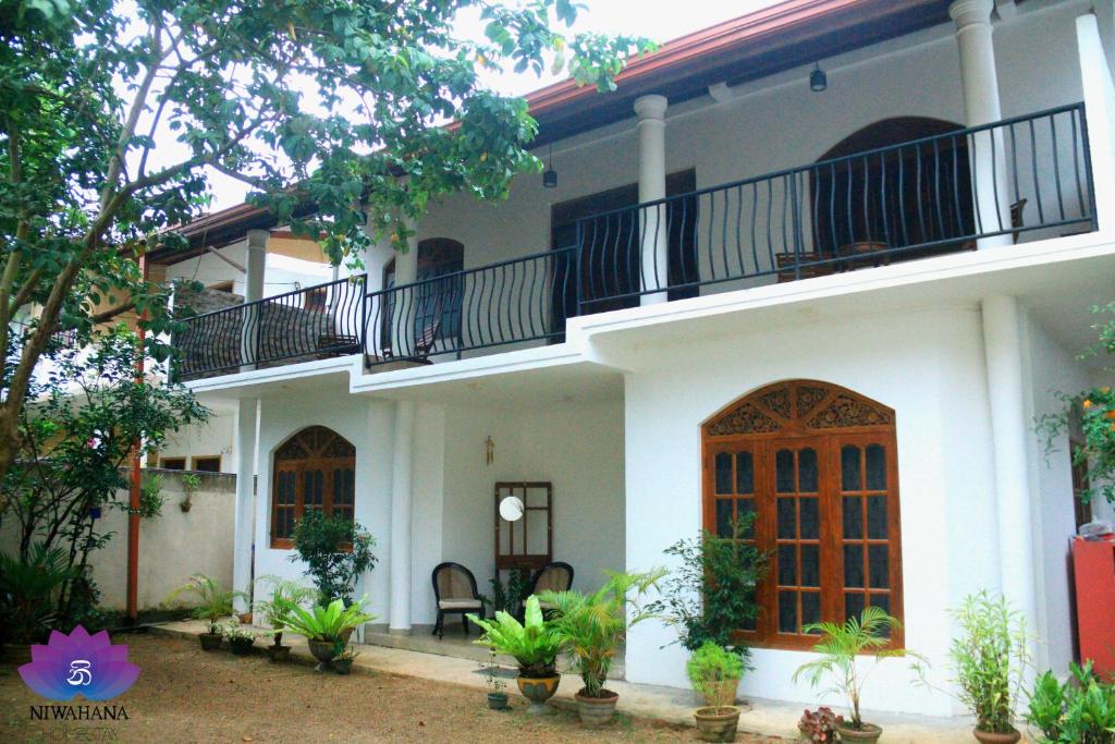 une maison avec 2 balcons au-dessus dans l'établissement Nivahana Homestay, à Kandy