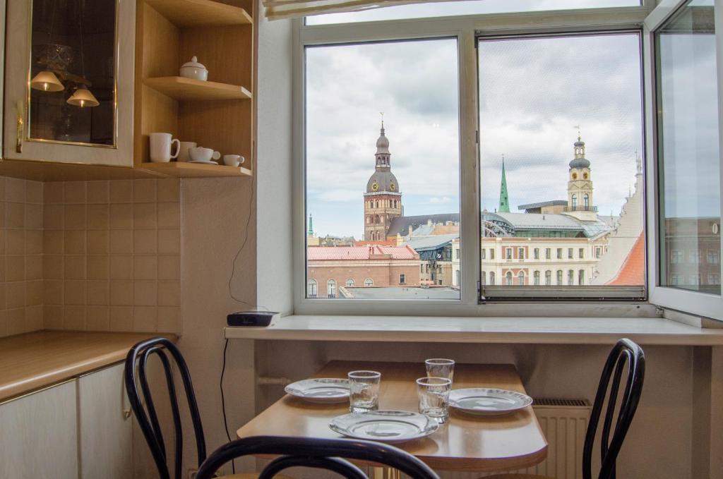 a table with chairs and a view of a city from a window at City Inn Riga Apartment Old Town Home with parking in Riga