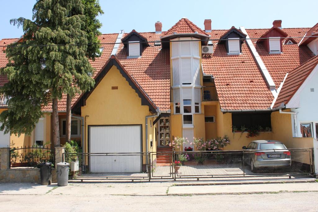 a large yellow house with a red roof at Abigél Vendégház in Harkány