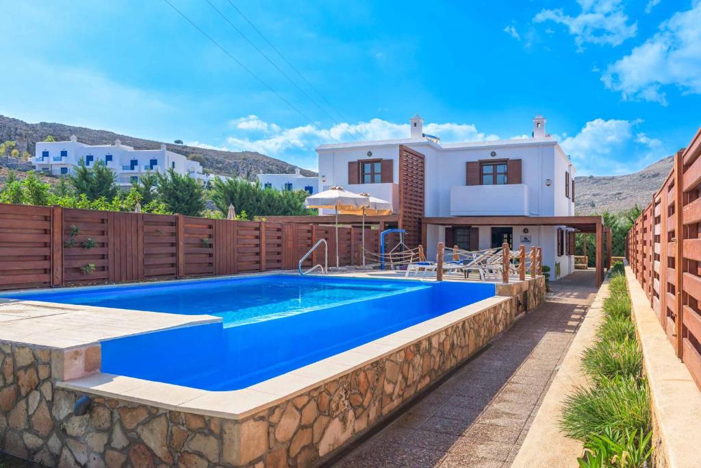 a villa with a swimming pool and a house at Lindos Sapphire in Líndos
