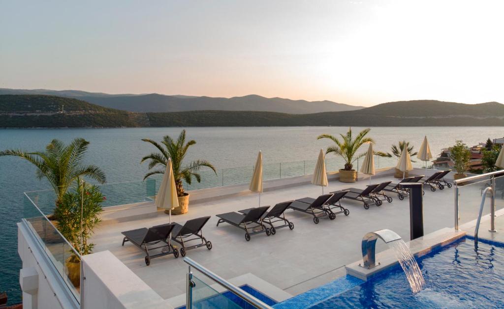 a resort with a pool and chairs and water at Hotel Nova in Neum