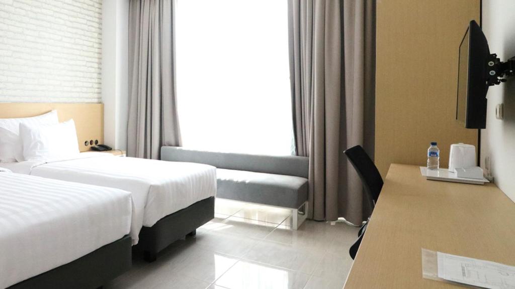 Postel nebo postele na pokoji v ubytování PALM PARK Hotel Surabaya