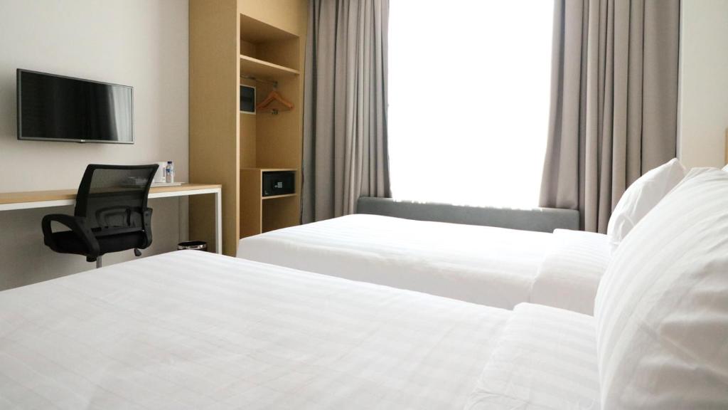 Postel nebo postele na pokoji v ubytování PALM PARK Hotel Surabaya