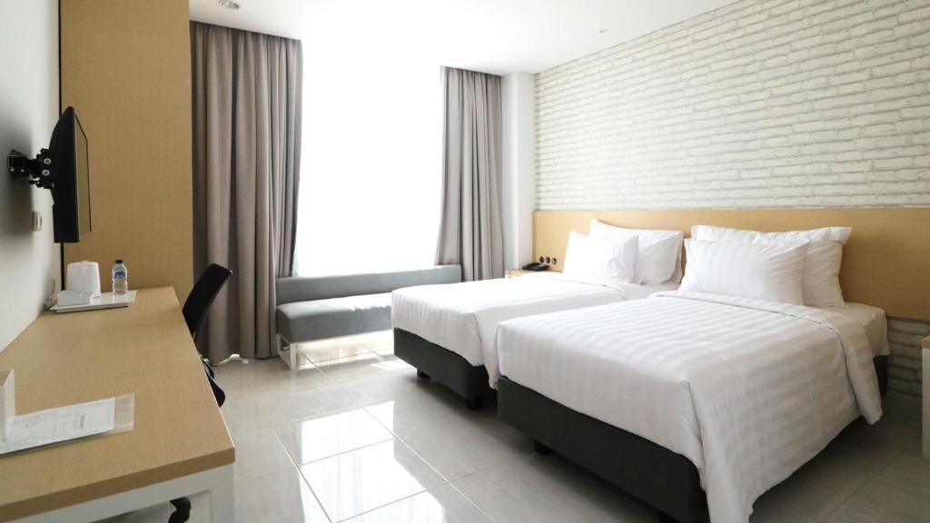 Postel nebo postele na pokoji v ubytování PALM PARK Hotel Surabaya
