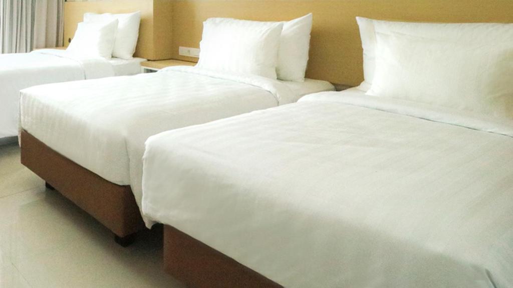 Postel nebo postele na pokoji v ubytování PALM PARK Hotel Surabaya