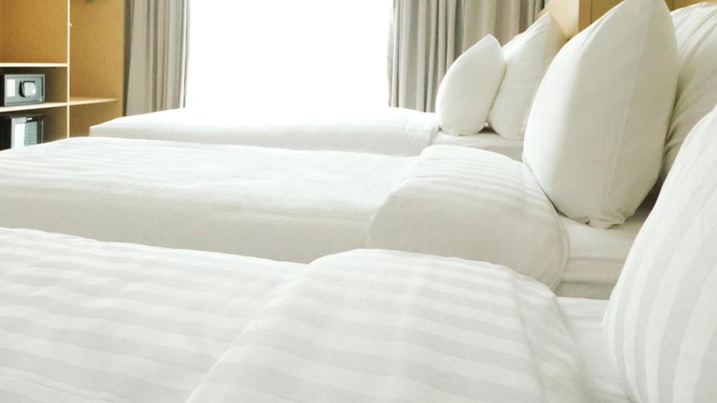 Postel nebo postele na pokoji v ubytování PALM PARK Hotel Surabaya