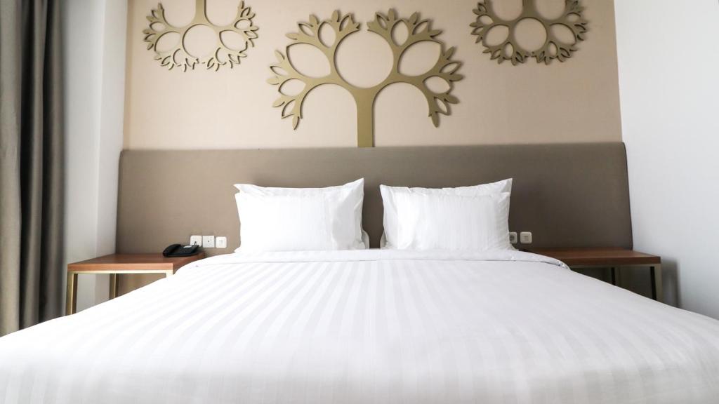 Postel nebo postele na pokoji v ubytování PALM PARK Hotel Surabaya