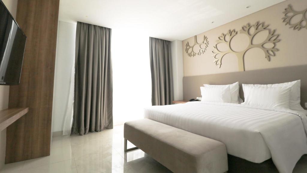 Postel nebo postele na pokoji v ubytování PALM PARK Hotel Surabaya