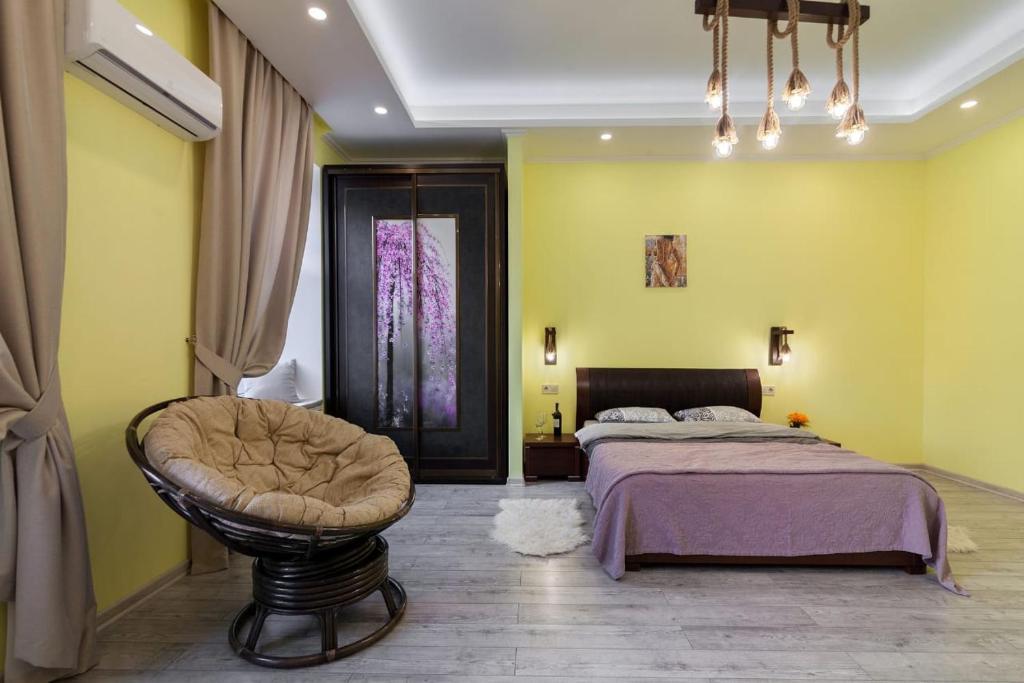 リヴィウにあるViP apartment in ♥ of Lvivの黄色の壁のベッドルーム1室、ベッド1台、椅子1脚が備わります。