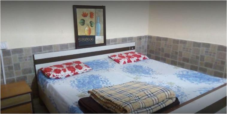 a bedroom with a bed with two pillows on it at Jheel Facing rooms in Bhimtal in Bhīm Tāl