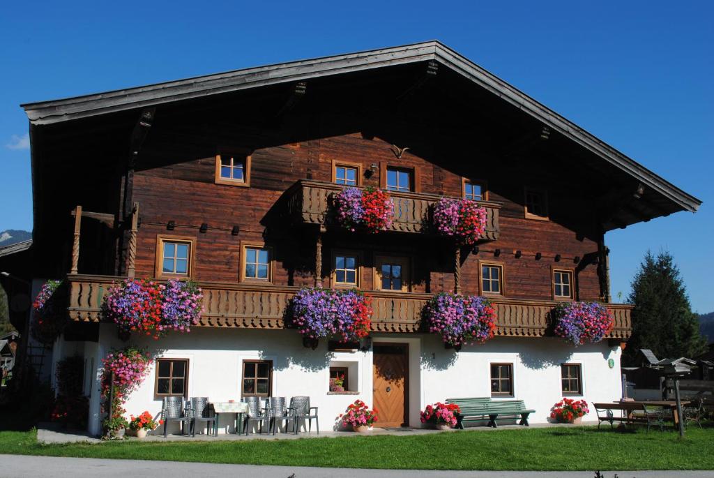 Un bâtiment avec des fleurs à l'avant dans l'établissement Ferienwohnungen Anderlbauer, à Lofer