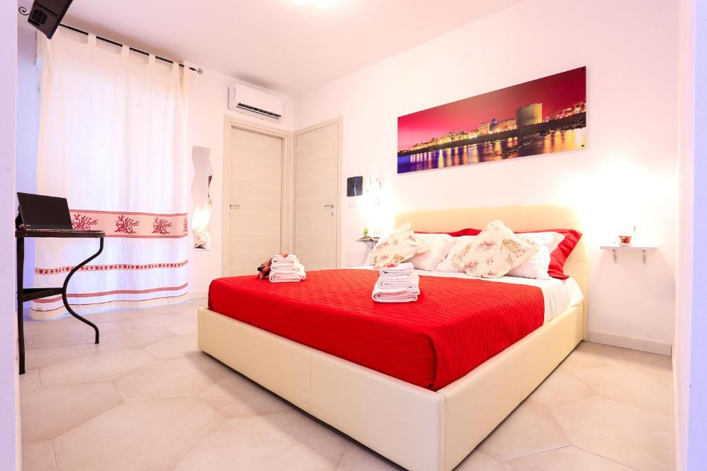 een slaapkamer met een groot bed en een rode deken bij Rosso di Mare Alghero in Alghero