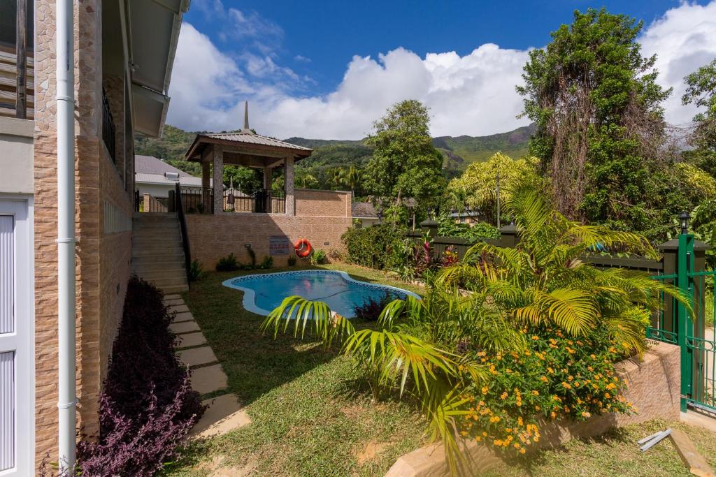 a backyard with a swimming pool and a gazebo at Beau Vallon Villa Chalets in Beau Vallon