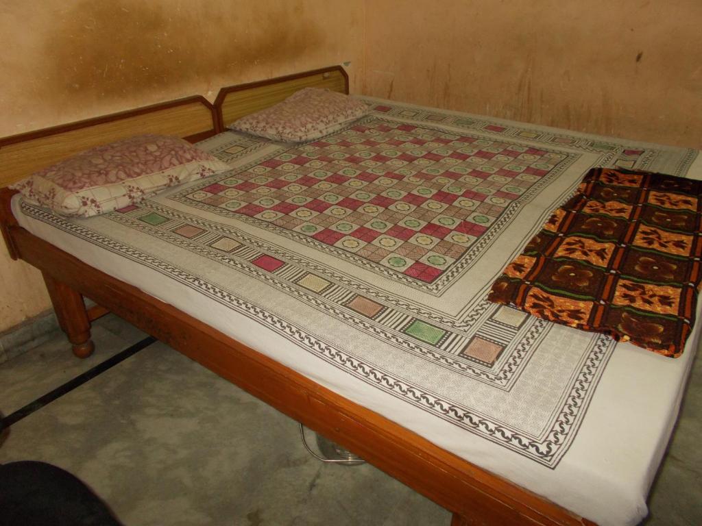 a bed with a quilt on top of it at Deluxe Stay near ISBT in Rishīkesh