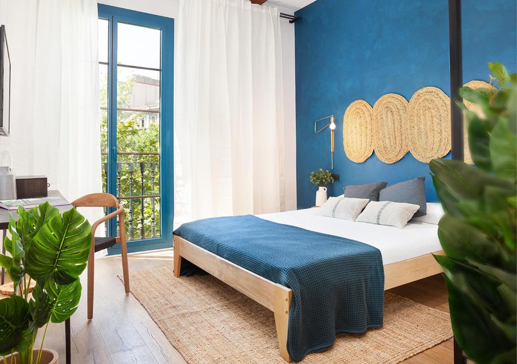 a bedroom with a bed with a blue wall at Casa Vaganto in Barcelona