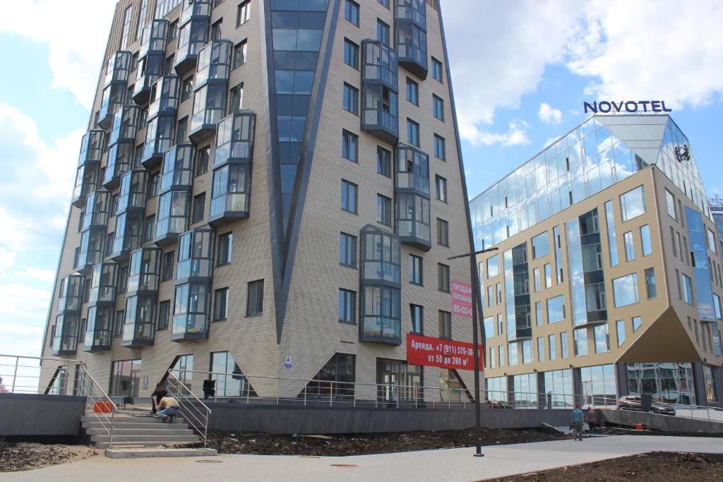 アルハンゲリスクにあるApartment Alpha on Naberezhnoy 52のガラス張りの隣の高層アパートメントビル