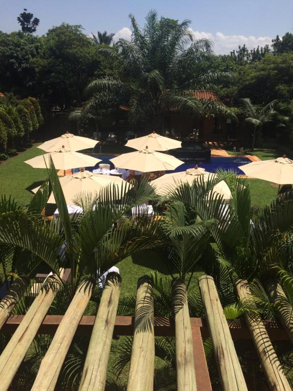 uma vista para um resort com guarda-sóis e palmeiras em No.5 Boutique Hotel em Entebbe