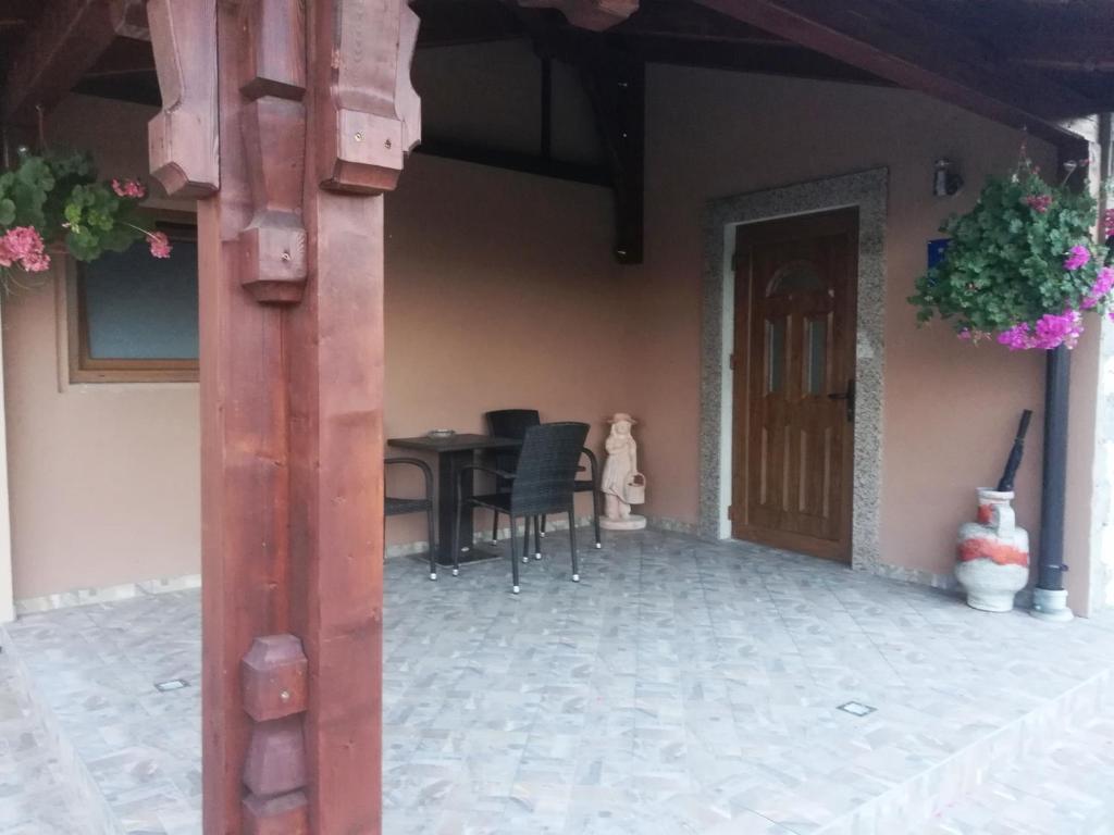 a porch of a house with a table and chairs at Sobe Pavlaković in Ozalj