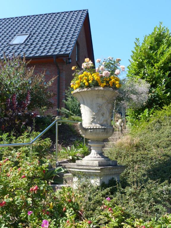 a large vase filled with flowers in a garden at Loft Sierksdorf in Sierksdorf