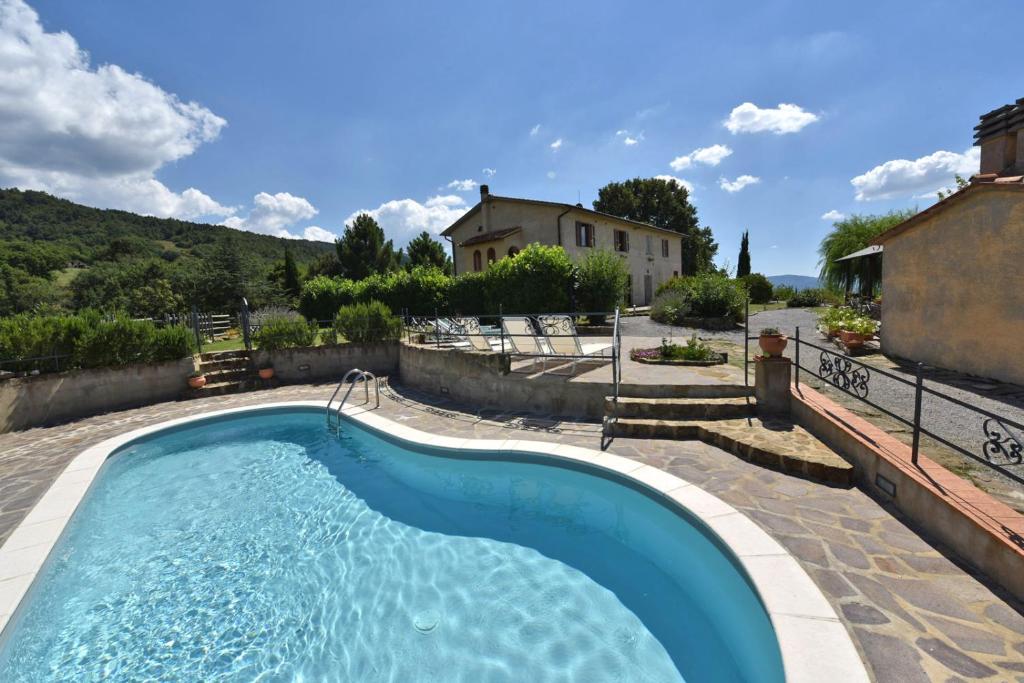 una piscina en un patio con una casa en Agriturismo Le Casaline, en Seggiano