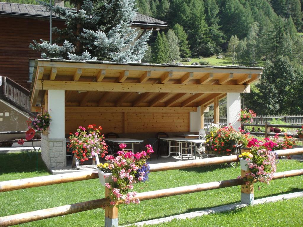a wooden pavilion with flowers on a fence at B&B Haus Granit Saas Grund in Saas-Grund