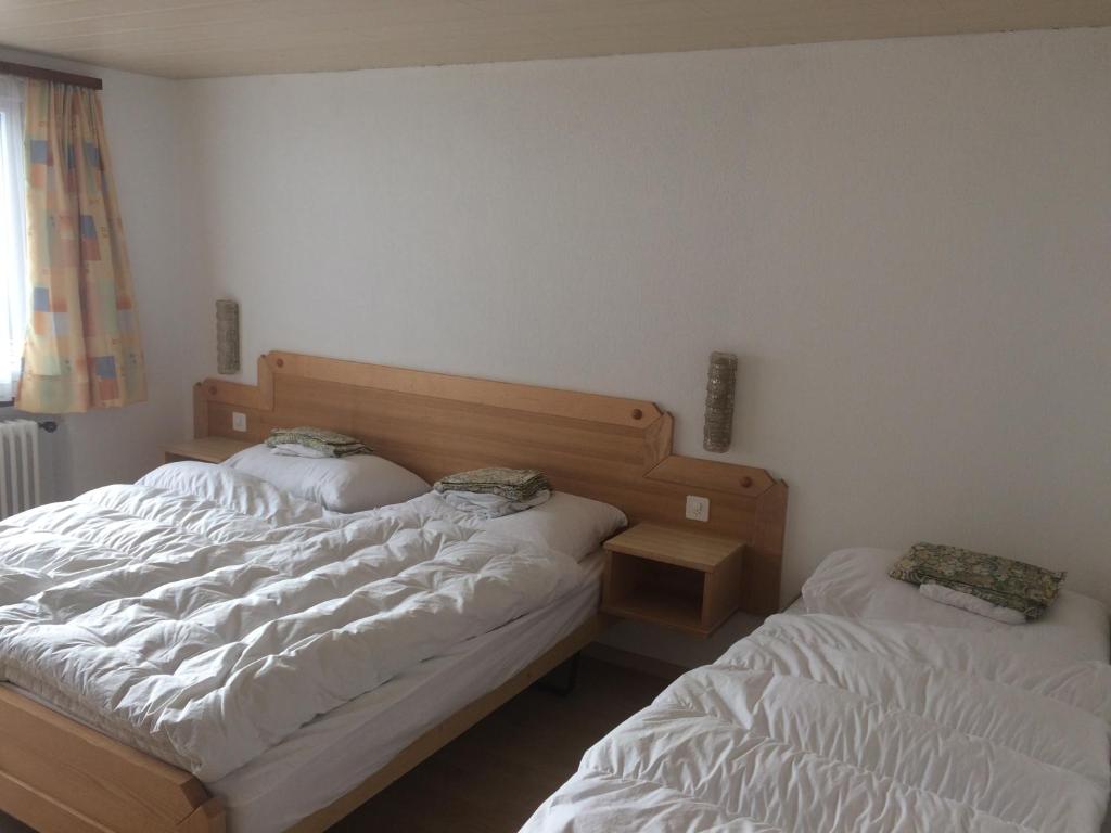 a bedroom with two beds and a night stand at B&B Haus Granit Saas Grund in Saas-Grund