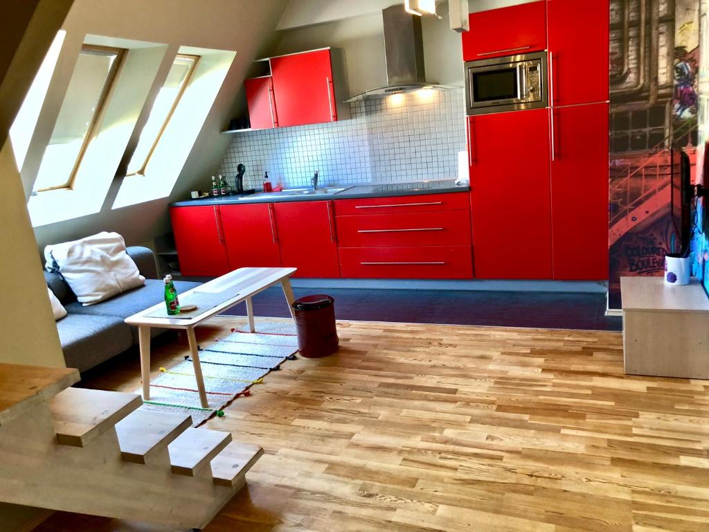 a kitchen with red cabinets and a table at Apartament Rolna CUBE27 in Poznań