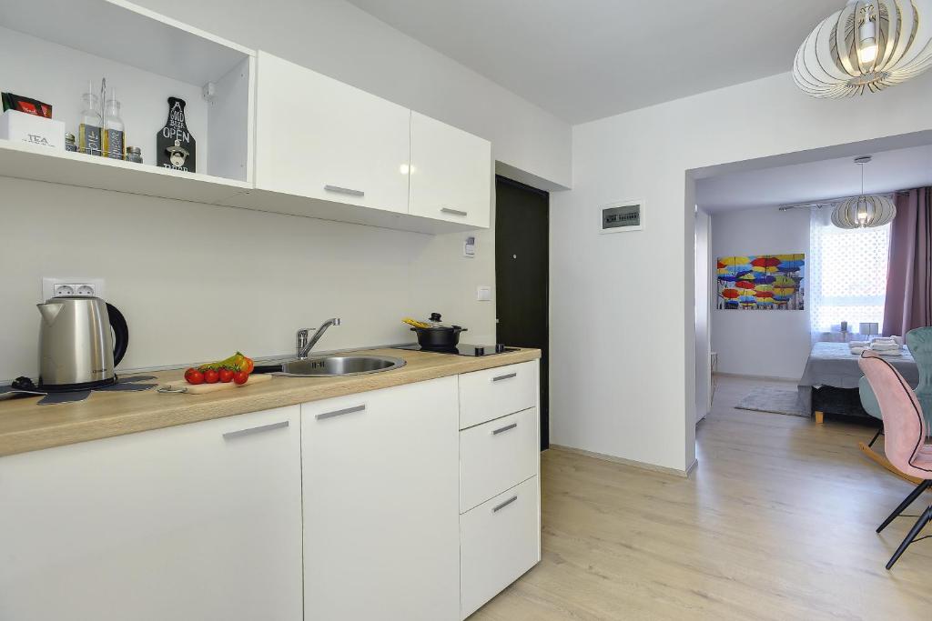 a kitchen with white cabinets and a counter top at D&A Amphitheatre Apartments with free parking in Pula