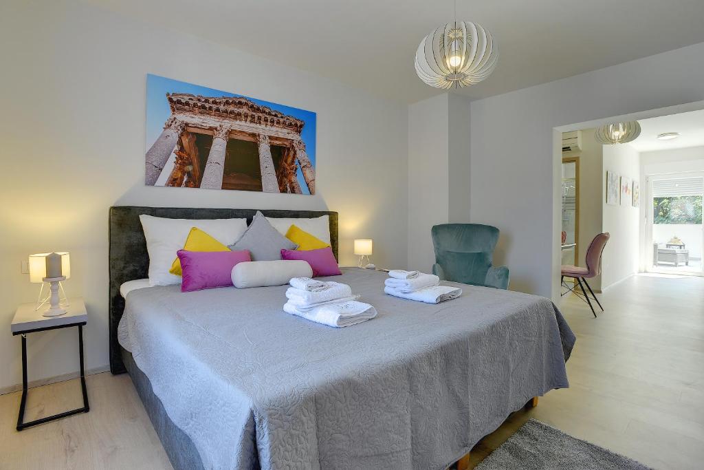 a bedroom with a large bed with towels on it at D&A Amphitheatre Apartments with free parking in Pula