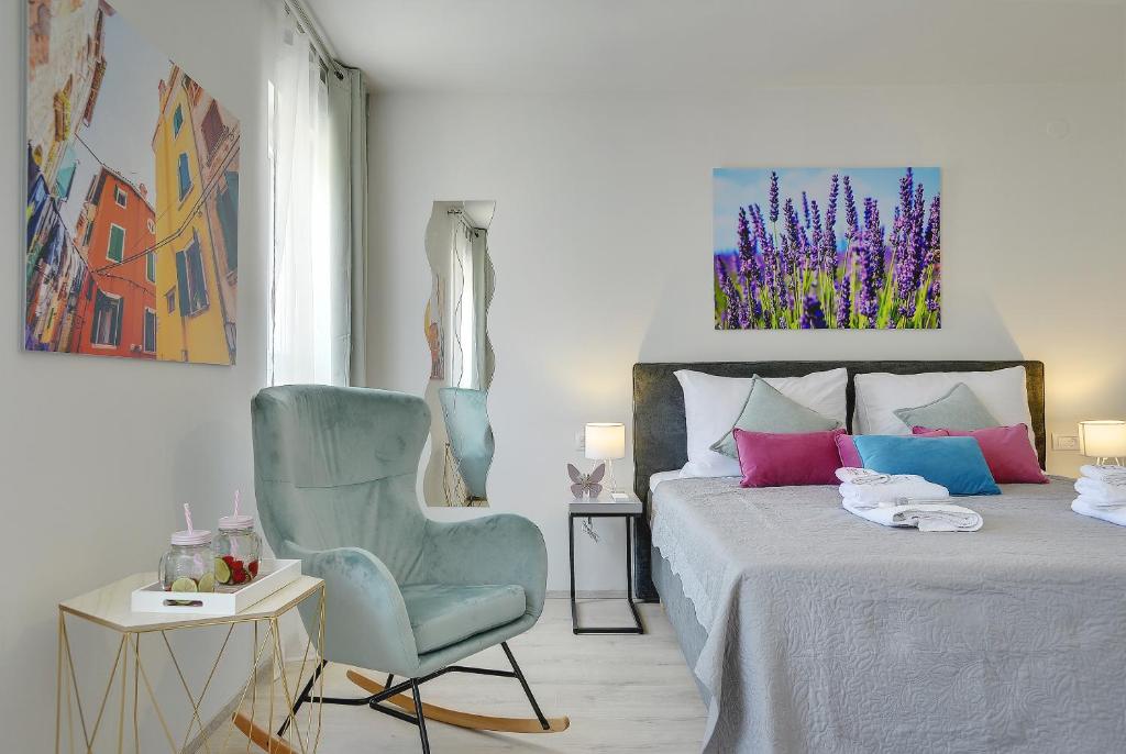 a bedroom with a bed and a blue chair at D&A Amphitheatre Apartments with free parking in Pula