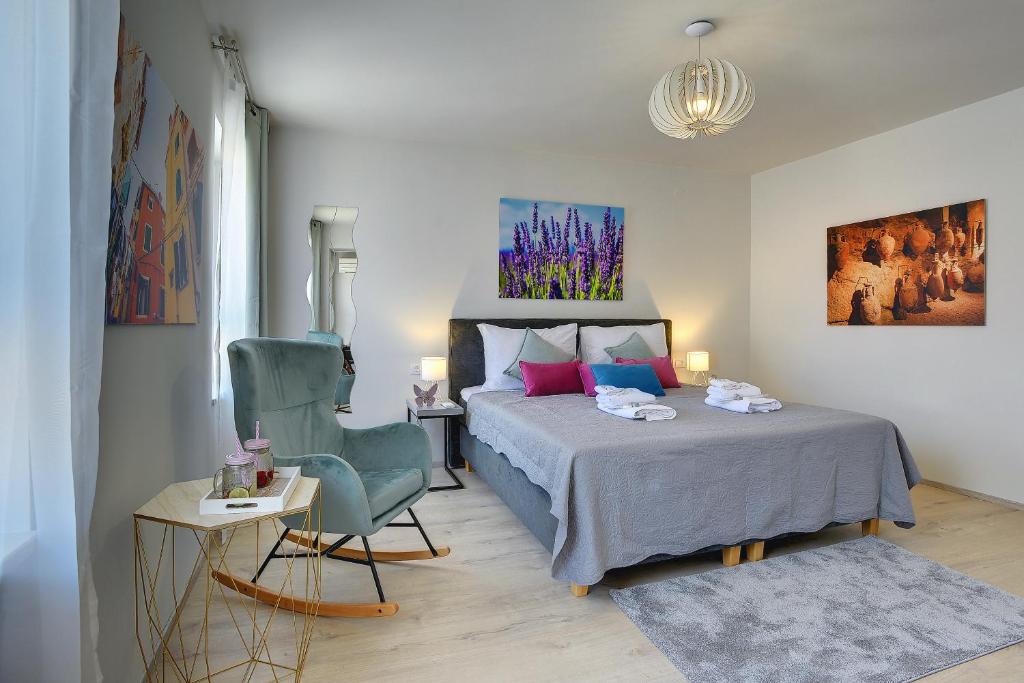 1 dormitorio con 1 cama y 1 silla en D&A City Center Apartments with free parking, en Pula