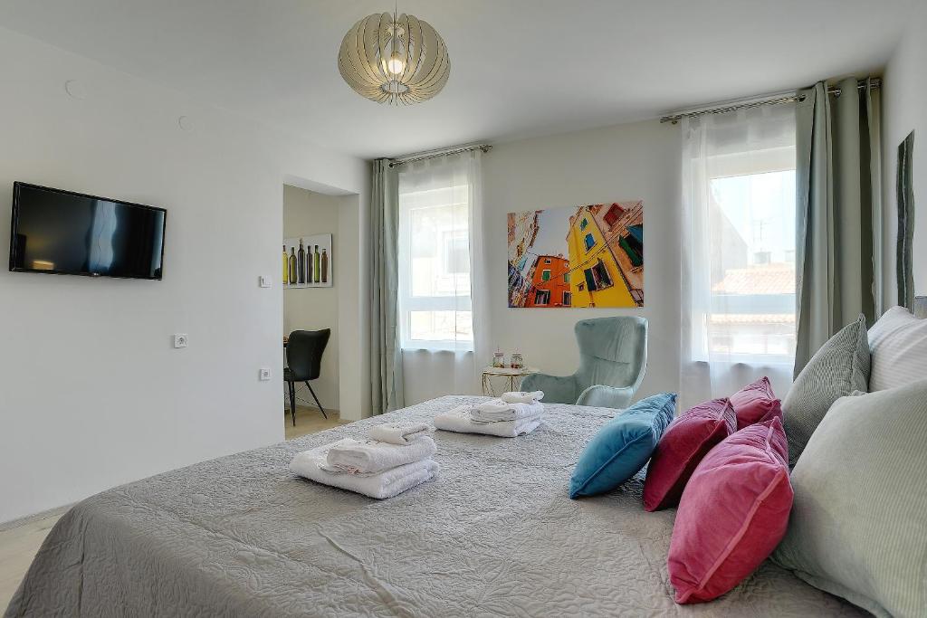 a bedroom with a bed with towels on it at D&A Amphitheatre Apartments with free parking in Pula