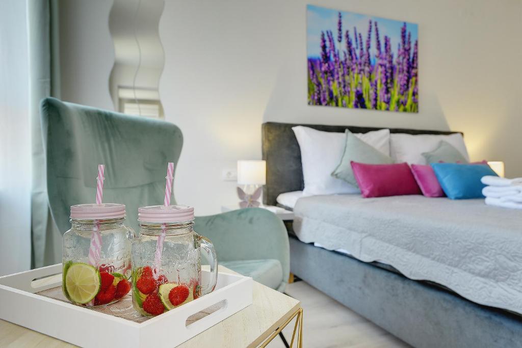a room with a bed and a tray with fruit in jars at D&A Amphitheatre Apartments with free parking in Pula
