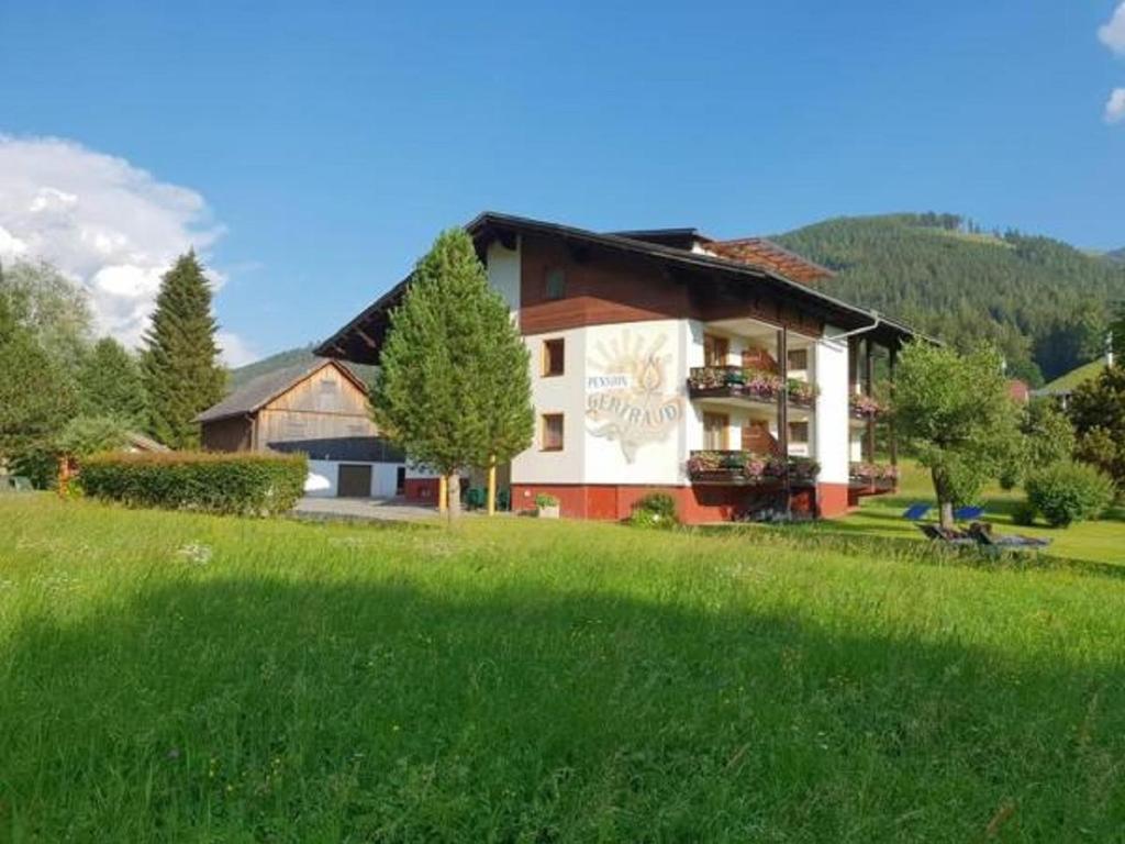 ein Haus auf einem Hügel mit einem grünen Feld in der Unterkunft Pension Gertraud in Bad Kleinkirchheim