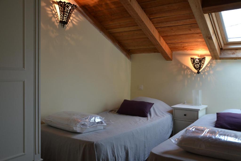 een slaapkamer met 2 aparte bedden en een raam bij Le Mathi in Fumel