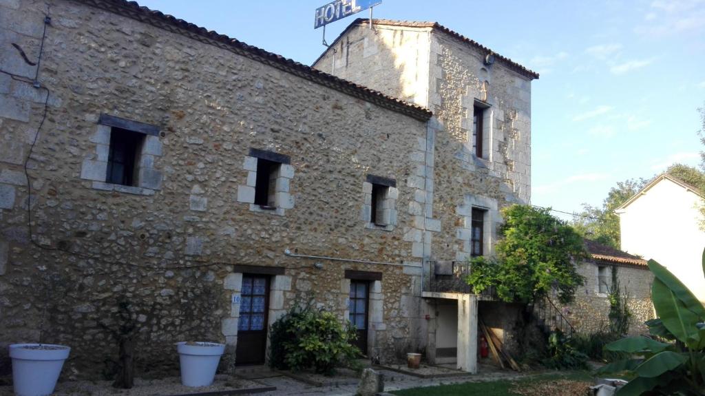 un antiguo edificio de piedra con un cartel en la parte superior en Les Tamaris, en Campsegret